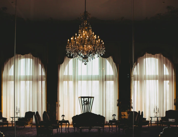 a room with two large windows and chandelier