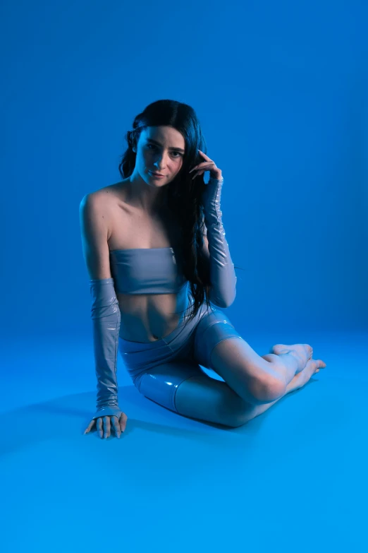 a woman posing on the blue background in latex