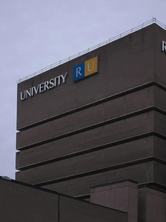 the top of a tall building with a blue and yellow logo on it