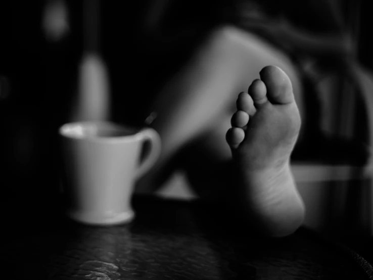 a person laying down with their feet propped up on the table