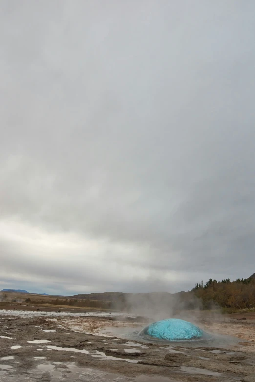 steam rises from the ground near a pond