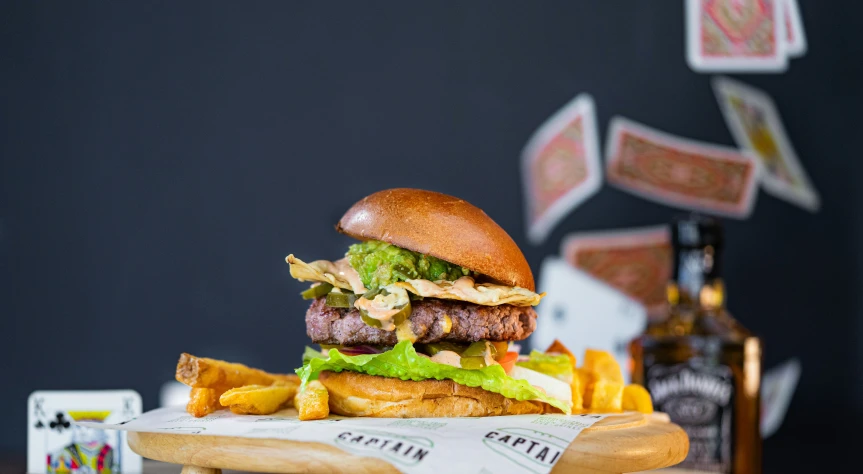 a double meat burger and fries on a wooden tray