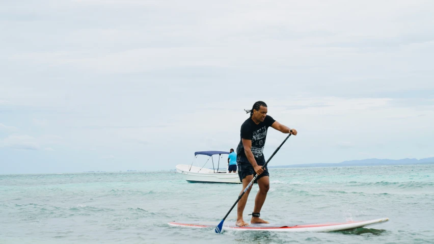 a man is riding his paddle board in the water