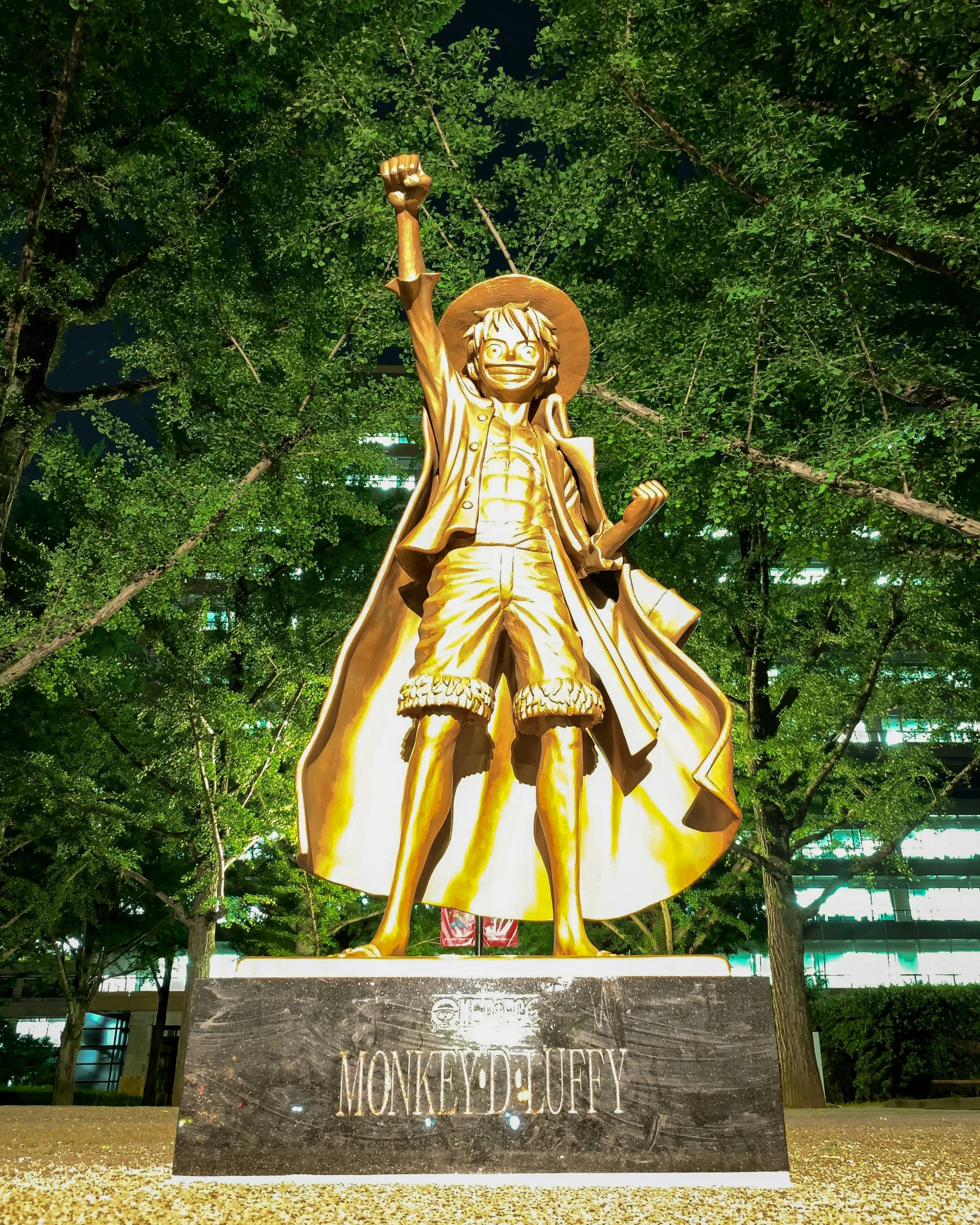a gold statue of a man with a sword in the park