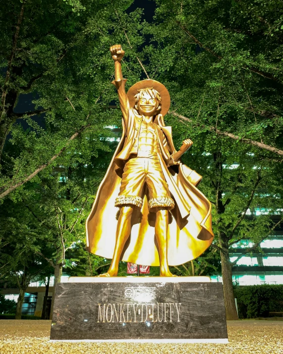 a gold statue of a man with a sword in the park