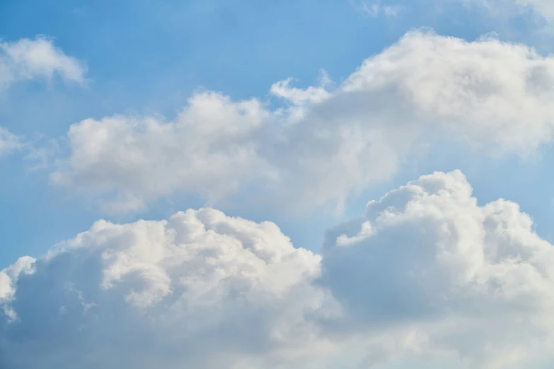 an airplane flying high in the sky with many clouds