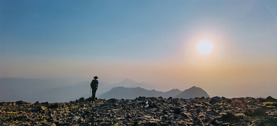 the person on the mountain looks into the distance