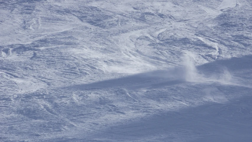 a person on a skis is descending down a snowy hill