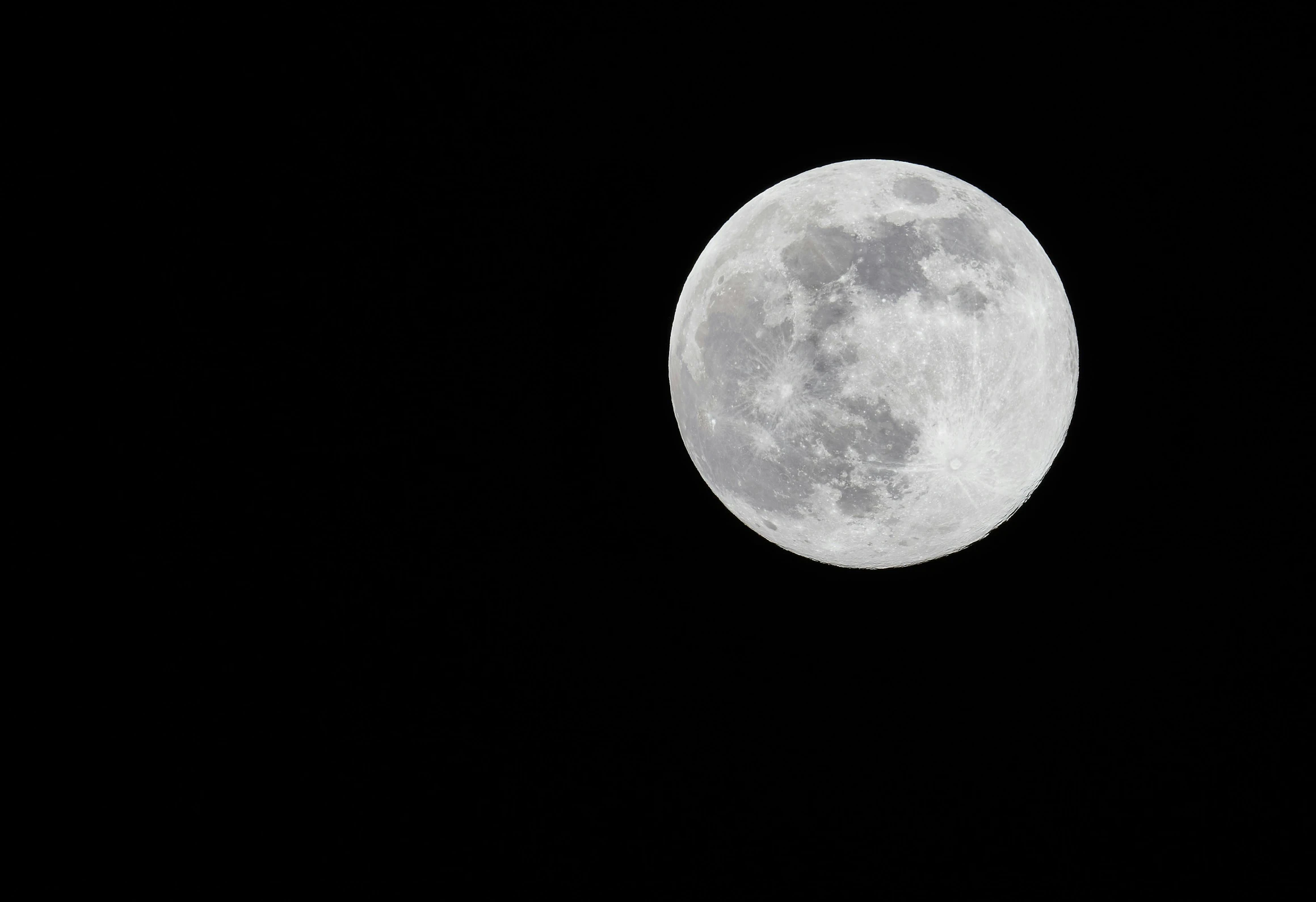 a very large full moon in the dark sky