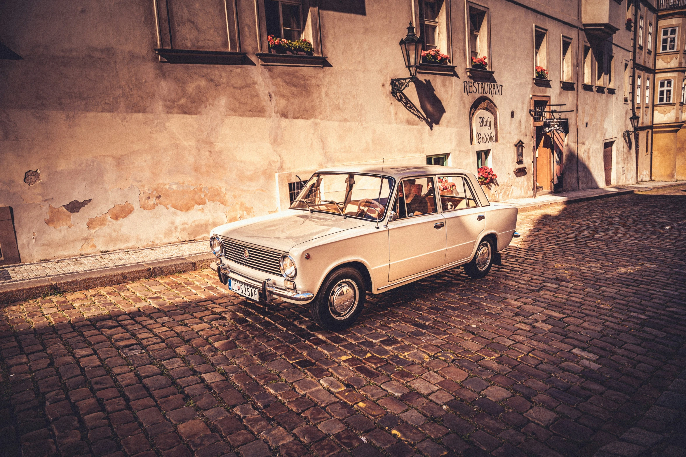 a small car parked on the side of a brick road