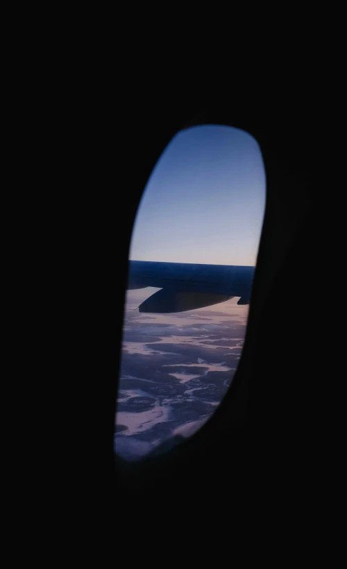 an airplane window view showing a beach and ocean