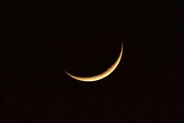 a crescent in the sky with its lights on