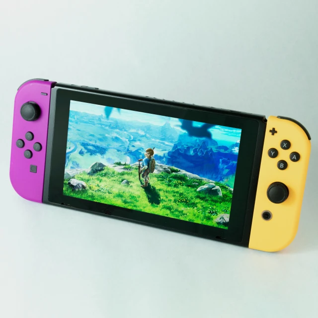 a pink and yellow nintendo switch game controller