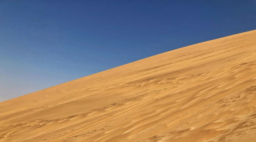 a person walking across a sandy area on skis