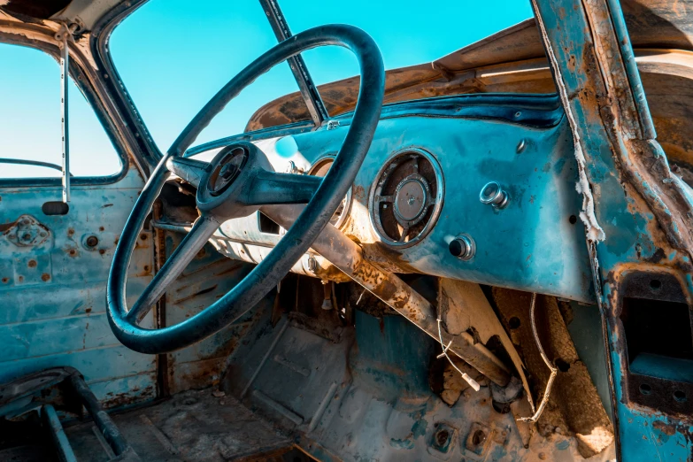 the interior of an old abandoned car with a steering wheel