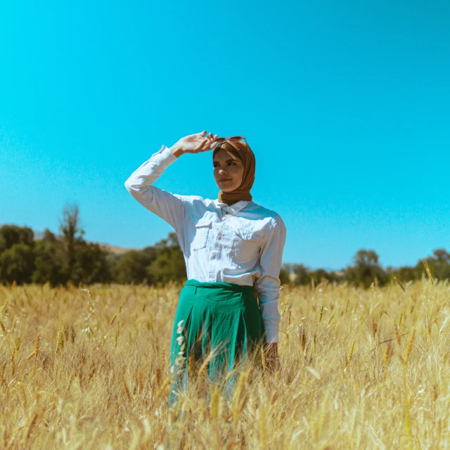 a girl in a field saluting the sun