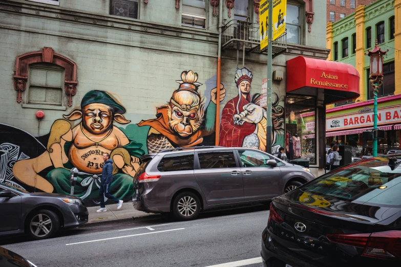 several cars are parked next to some big graffiti