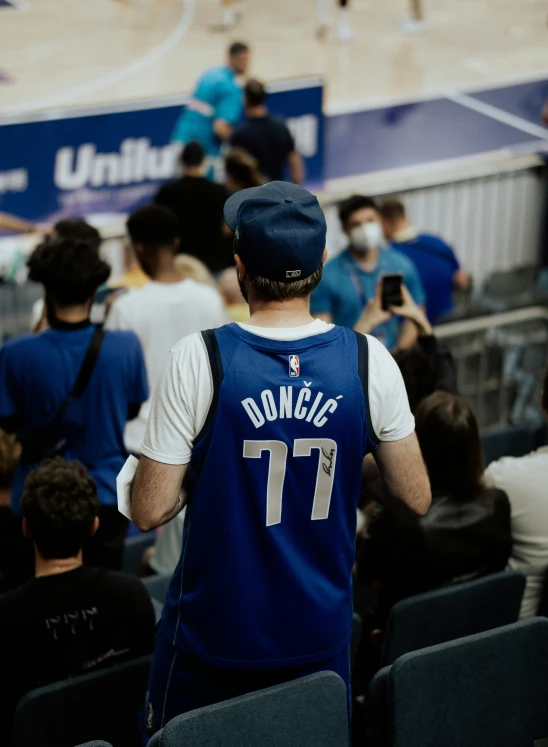 a basketball player standing in a stadium with a hat on his head