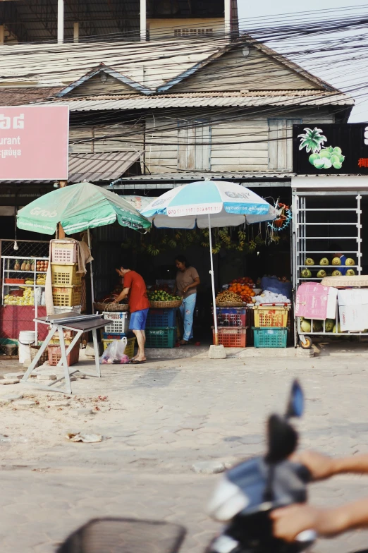 a couple of people standing at an open air market