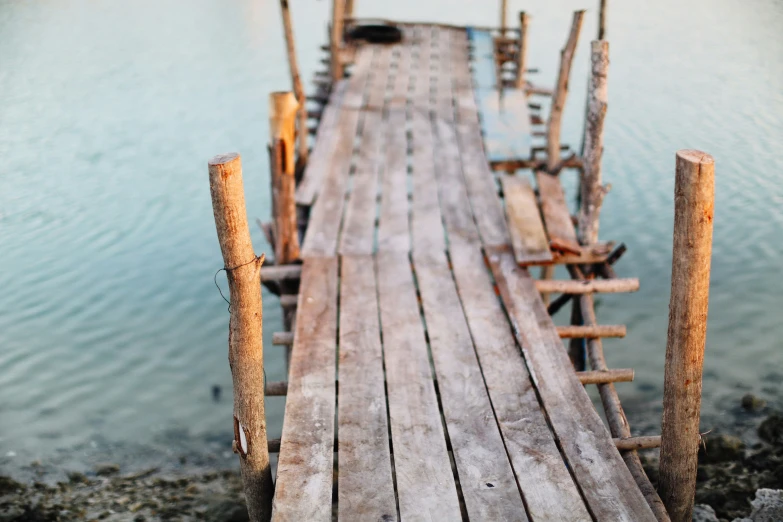 a wooden dock with several old style handmade boats on it