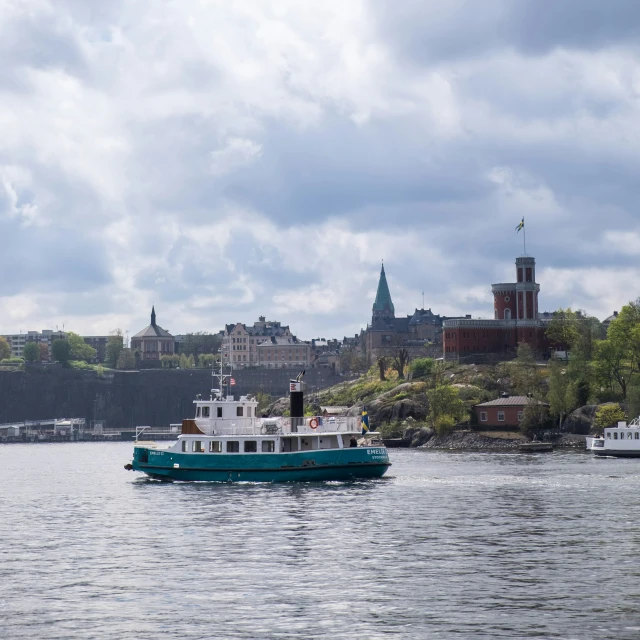 a blue boat traveling past the shore of a river