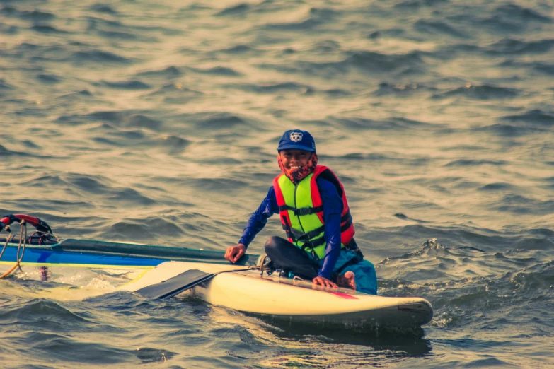 a man in a helmet is on a surfboard and on the water