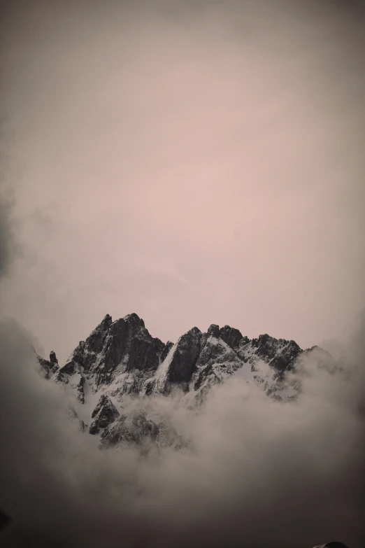 the clouds are gathering around mountains and a sky