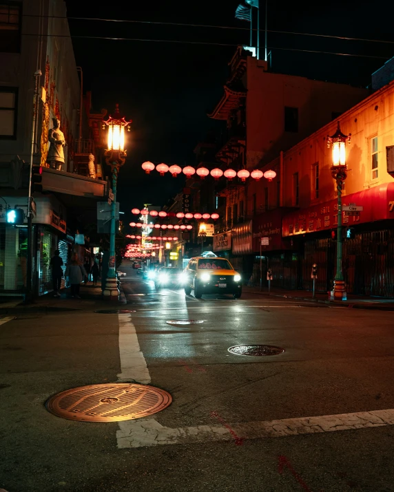 a busy city street in the evening with street lights above it