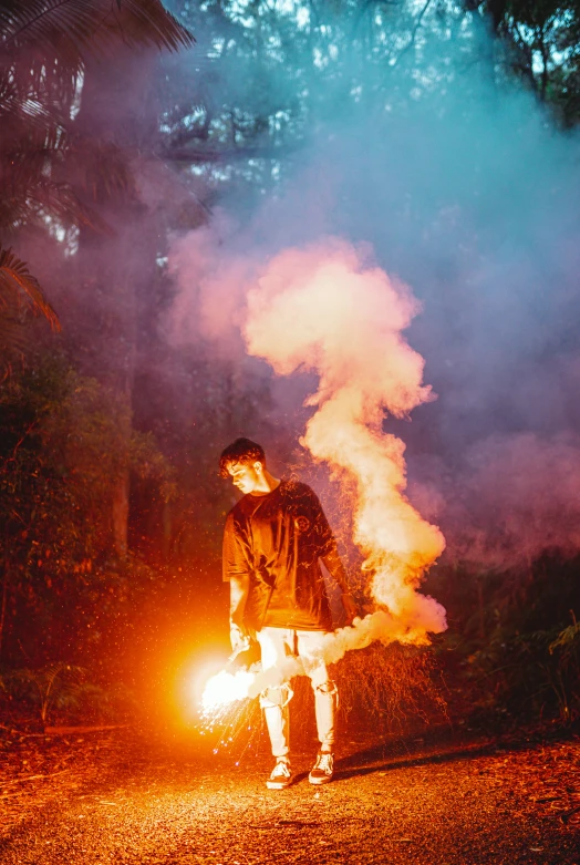 a man is standing outside in the night with a lit fire