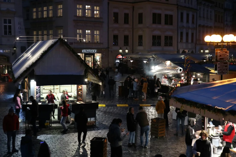 crowds are gathering on the street corner at night