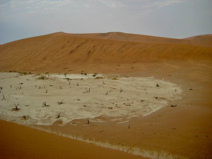 a large sand hill and some people standing in it