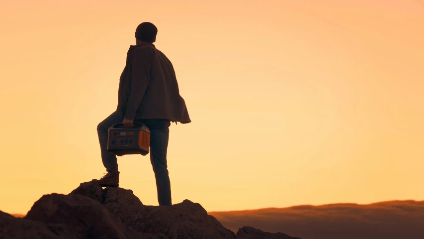 a silhouetted statue with a briefcase on a mountain