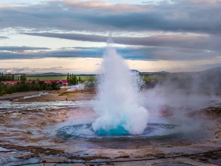 a large geyser spewing water out of a pond into a sky