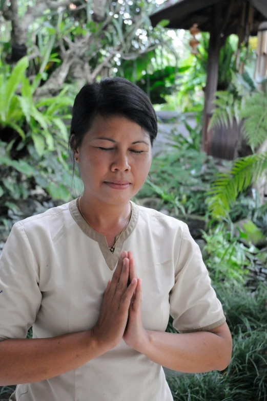 woman in a white uniform sitting with her hands folded on her chest