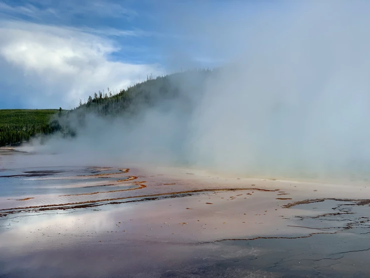 a large geyser emits steam into the sky