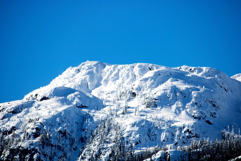 a snow covered mountain, with snow on the top