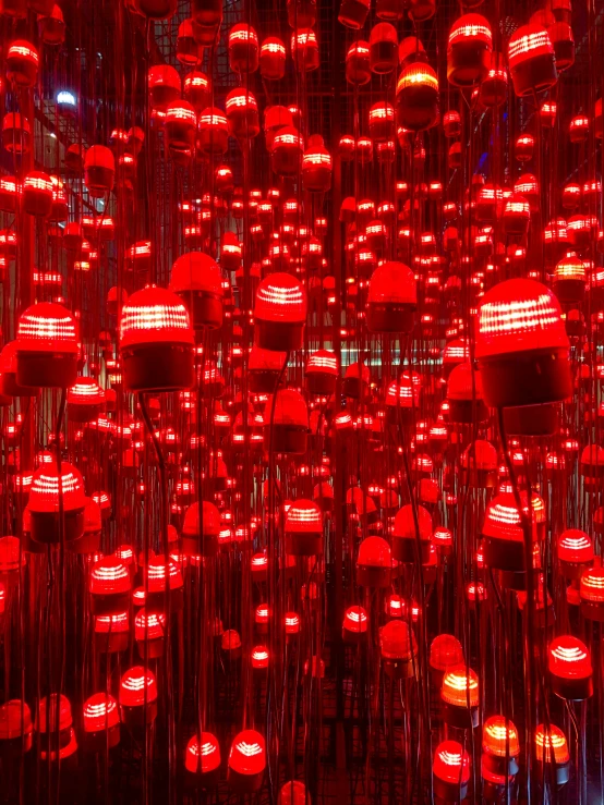red lights hang from strings in front of a wall