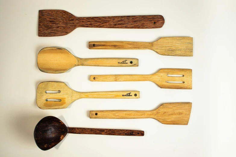 the wooden utensils are lined up on the table