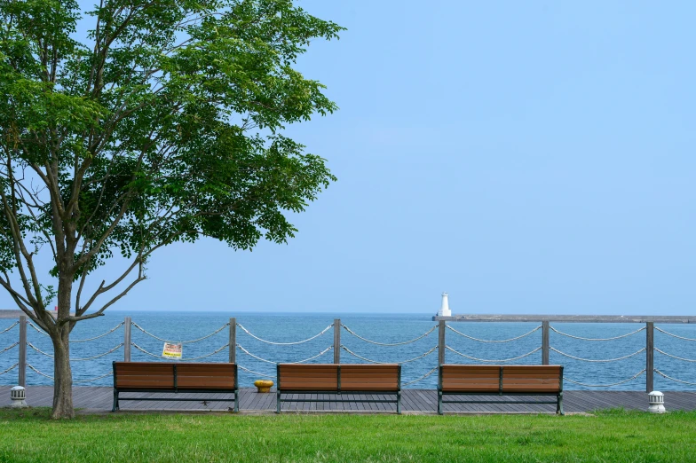 three benches in a row on the side of a waterfront