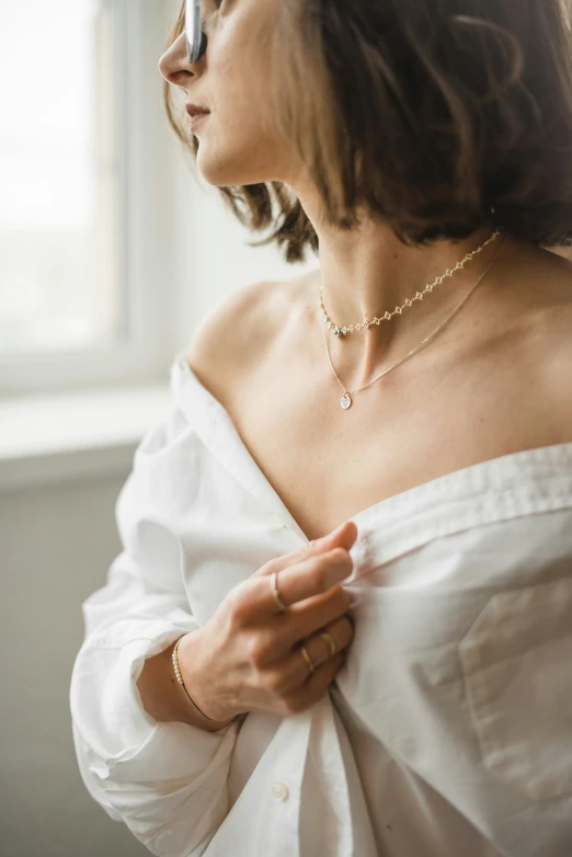 a woman in a white shirt wearing an elaborate necklace