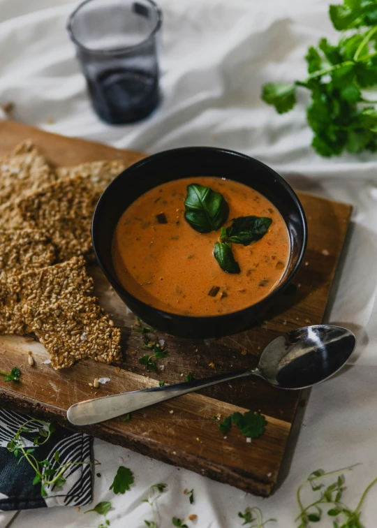 there is a bowl of soup on a  board