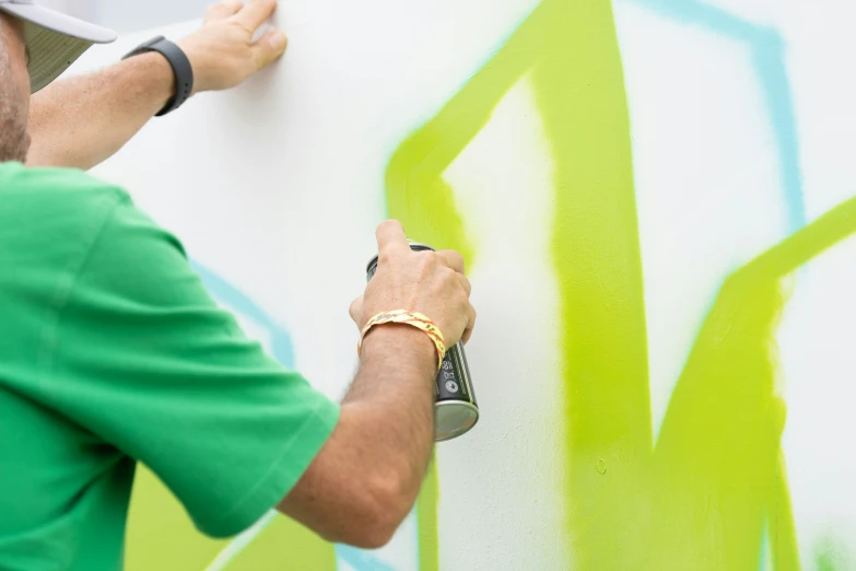 someone painting a wall with bright green paint