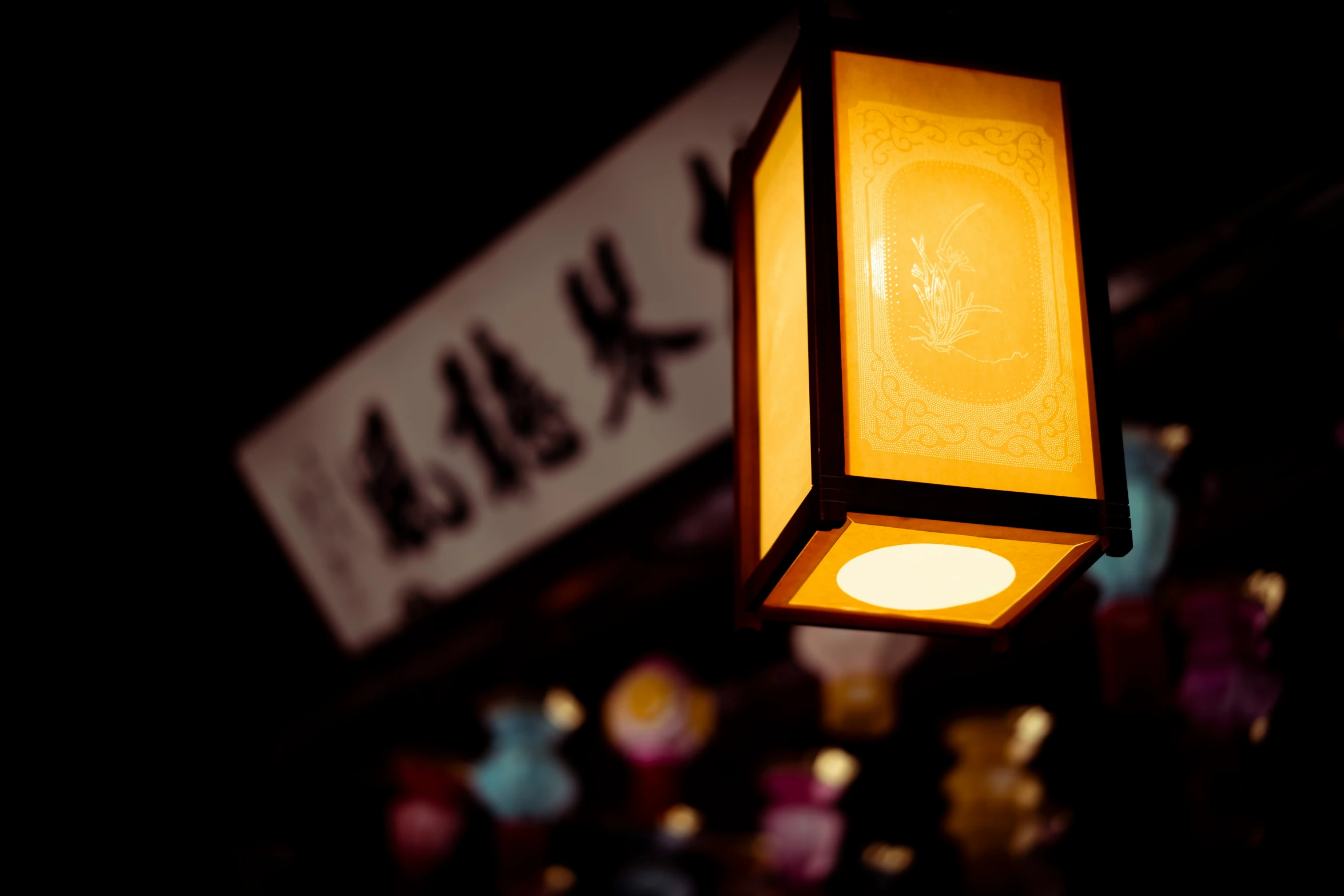 a glowing lamp in the dark near a store sign
