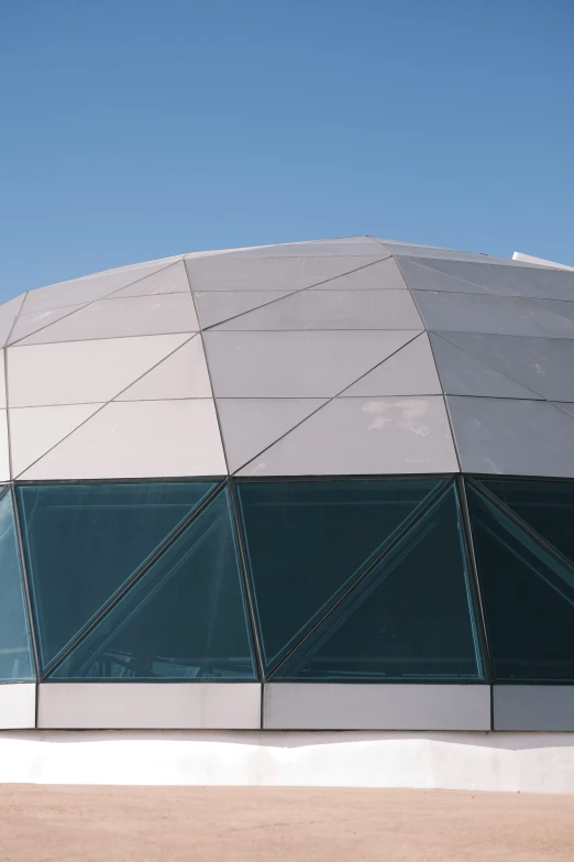 an airplane flies past a large glass building