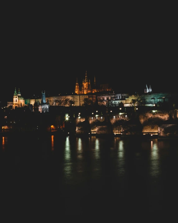 a large castle lit up at night over a city