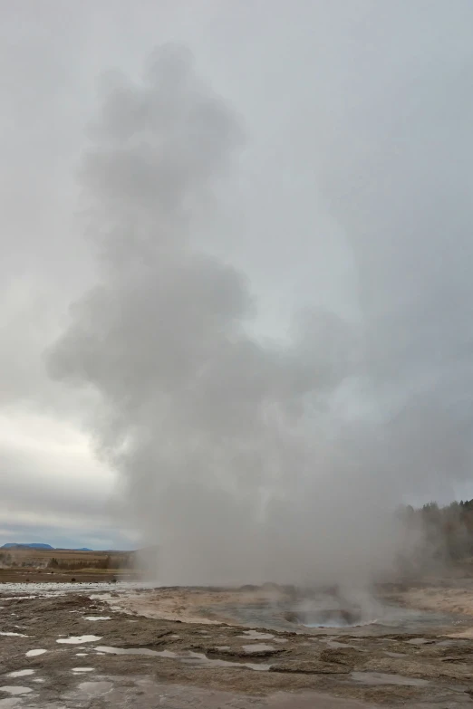 a small geyser next to a road in the desert