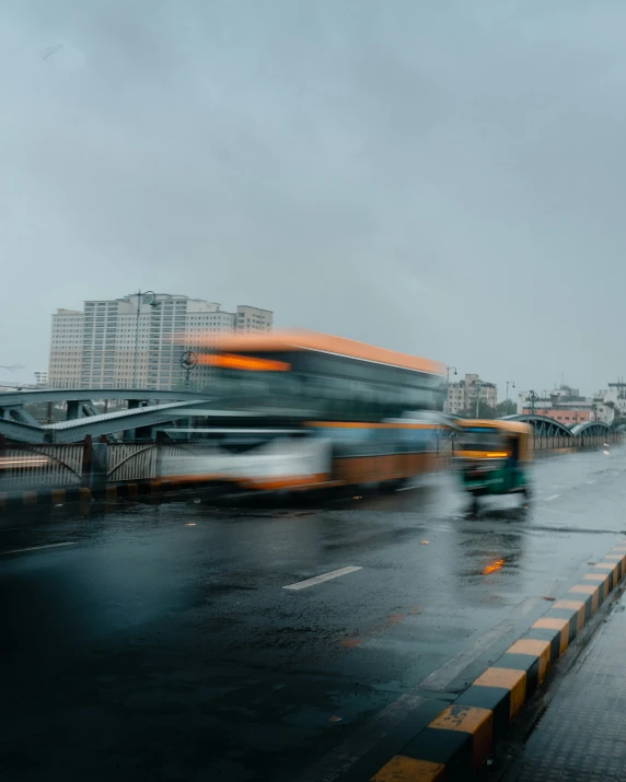 a bus on a rainy day passing by buildings