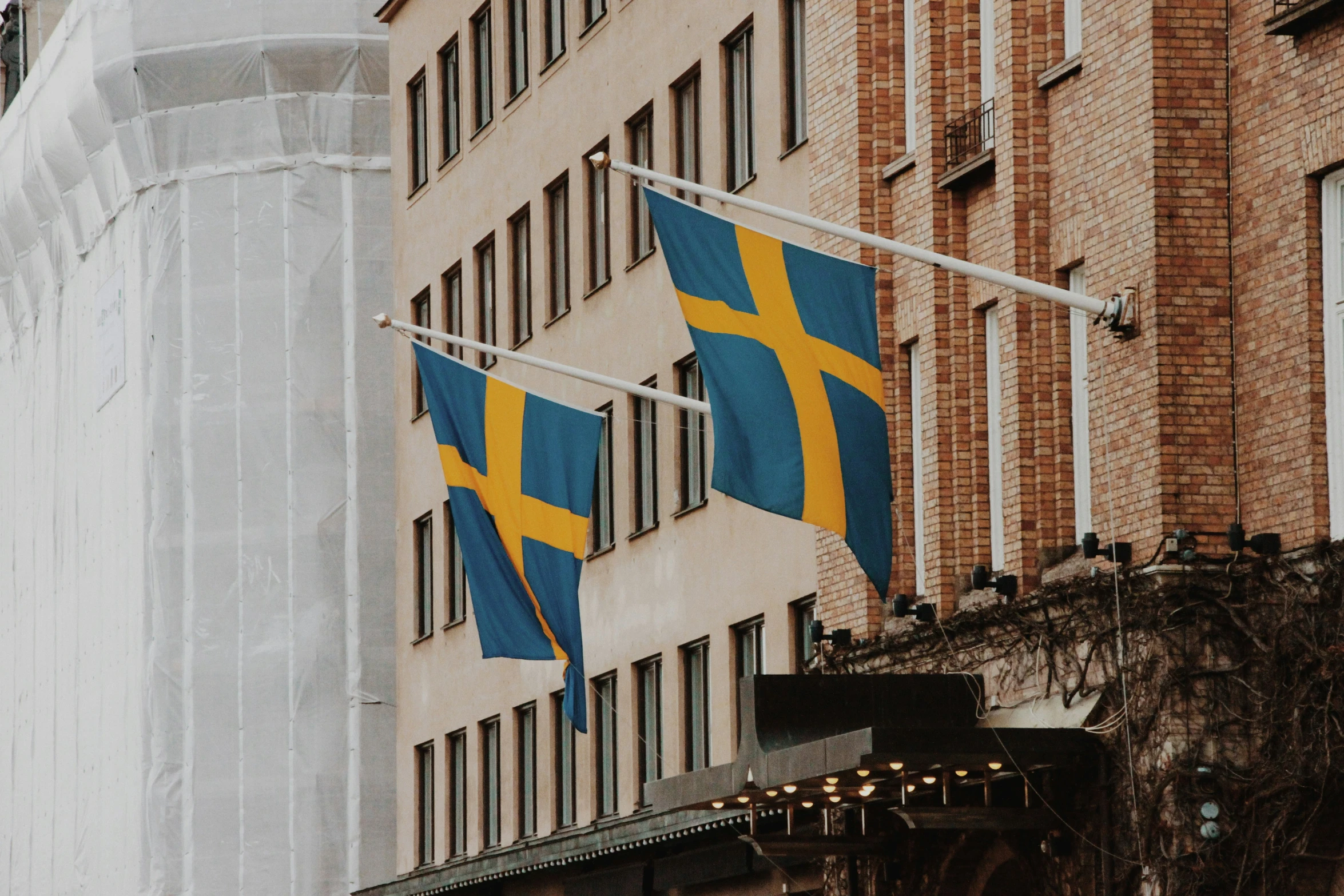 two swedish and yellow flags hanging from a building