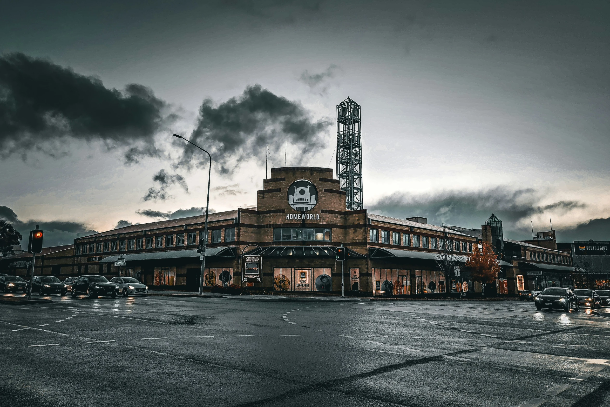 a building sitting in a parking lot with clouds above