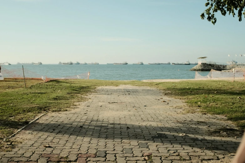 a paved path leads to the water and is in front of some boats